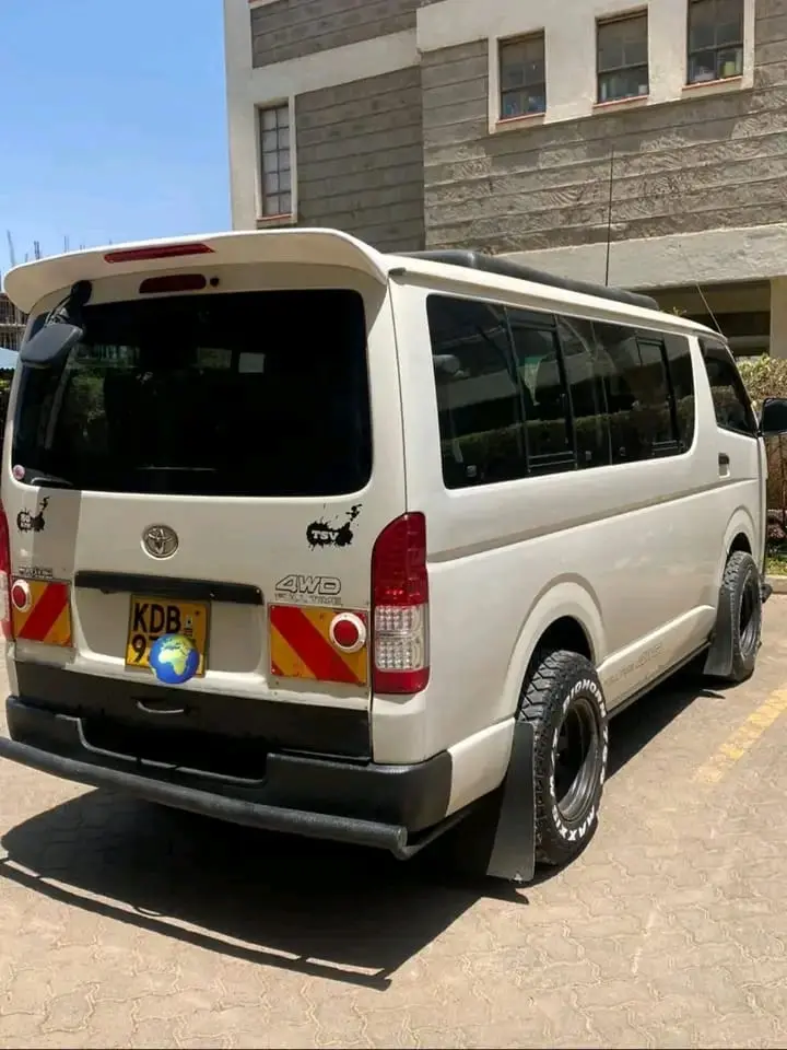 Silver Toyota Hiace passenger shuttle photographed from the rear